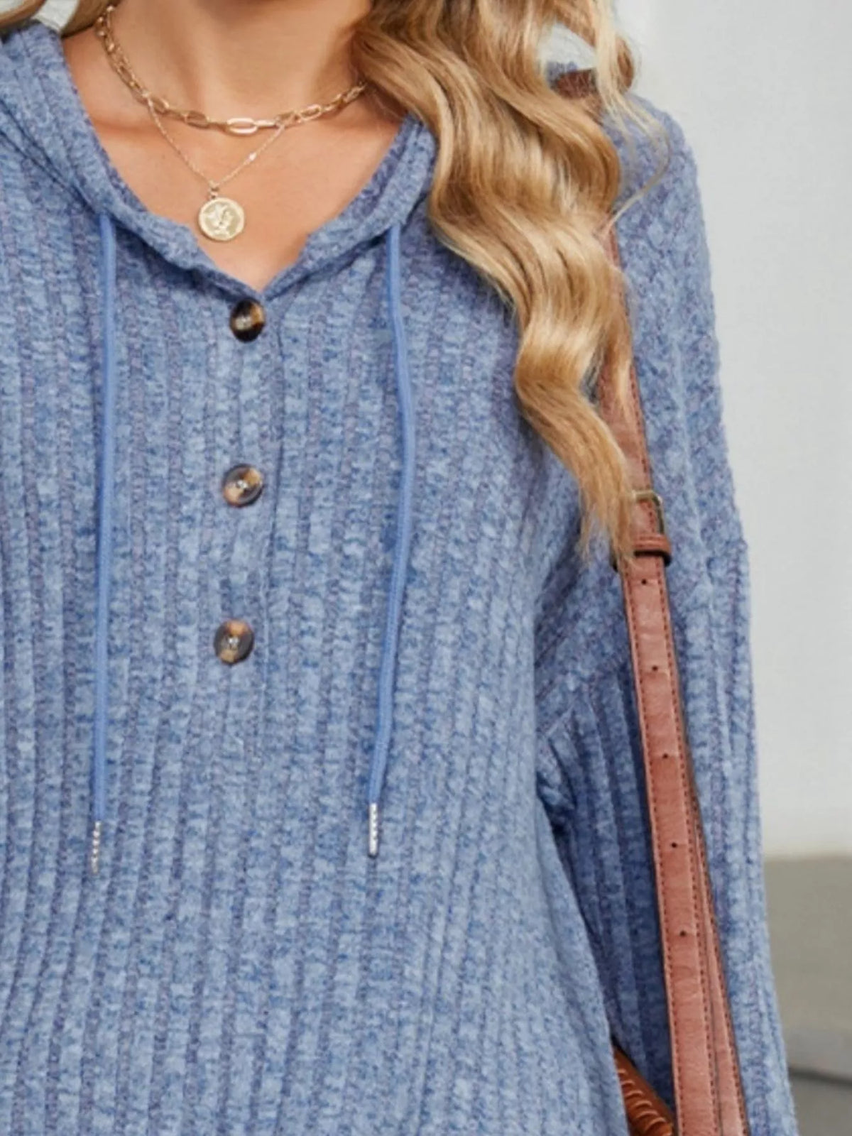 Light blue ribbed knit hoodie with hood drawstring and wooden-look buttons.