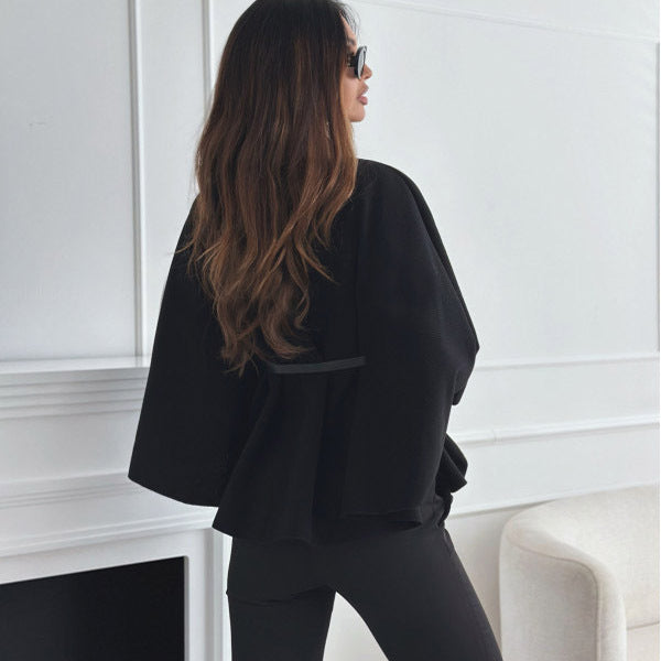 Women’s black cloak top with stand collar, batwing sleeves, and belt detail