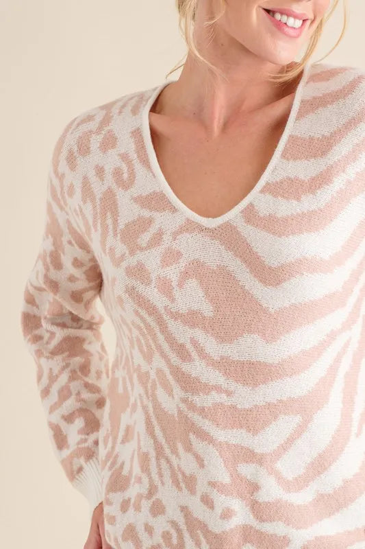Pale pink V-neck sweater top close-up with mixed zebra and leopard knit pattern