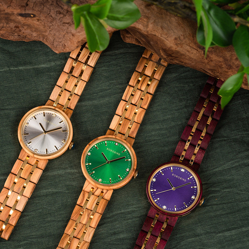 Three-color womens quartz watch set with round dials in gold, green, and purple on link bands