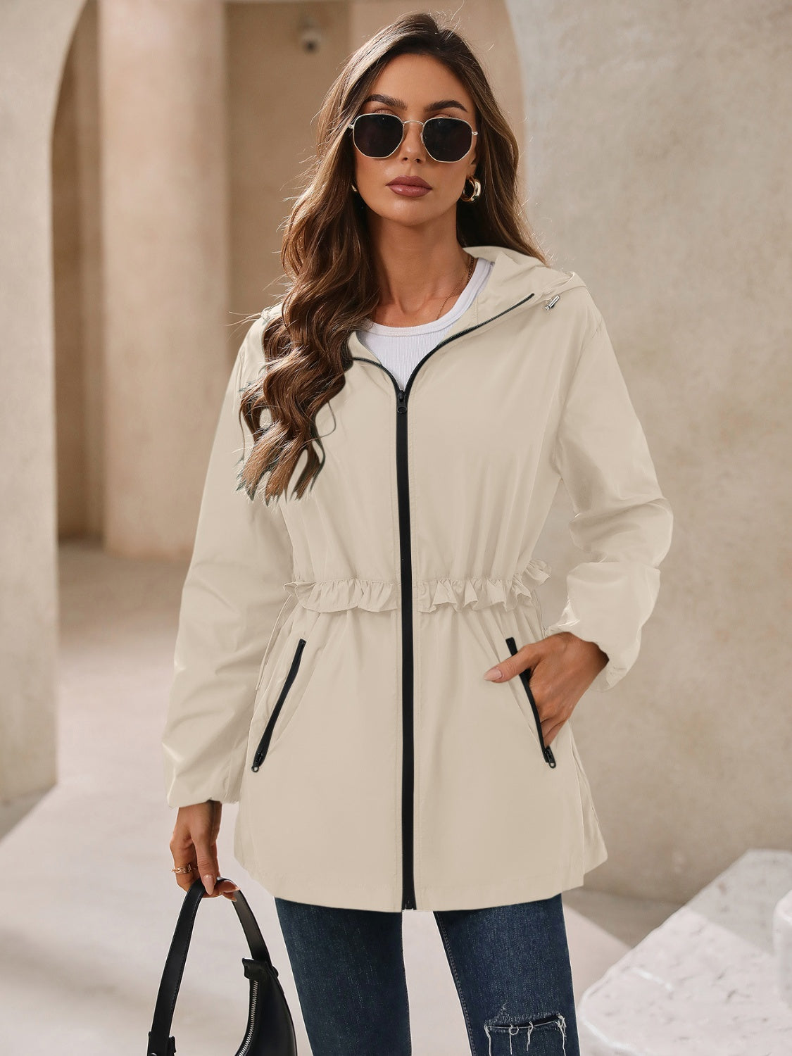Tan hooded windbreaker jacket with zip front and gathered waist, front view