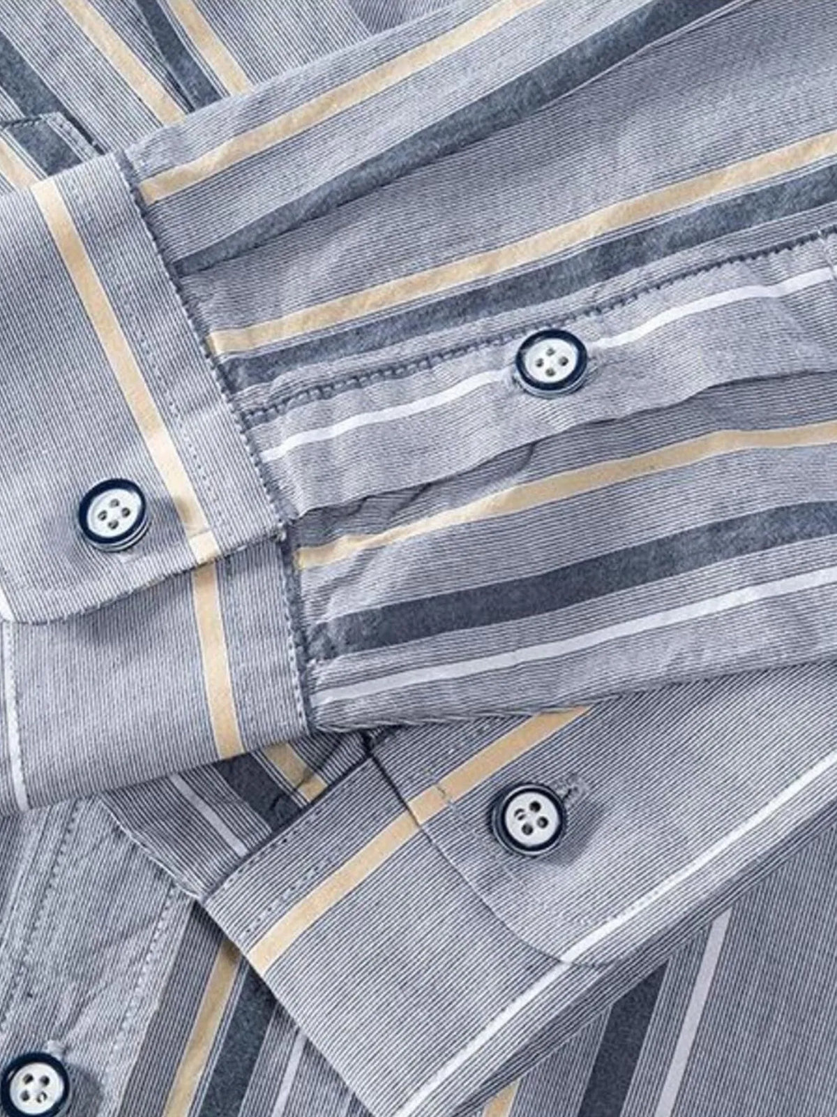 Close-up of light gray striped shirt cuffs and buttoned sleeve placket.