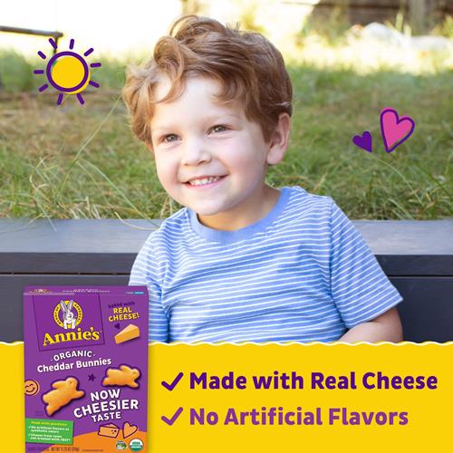 Organic cheddar bunny snack crackers box held by smiling child.