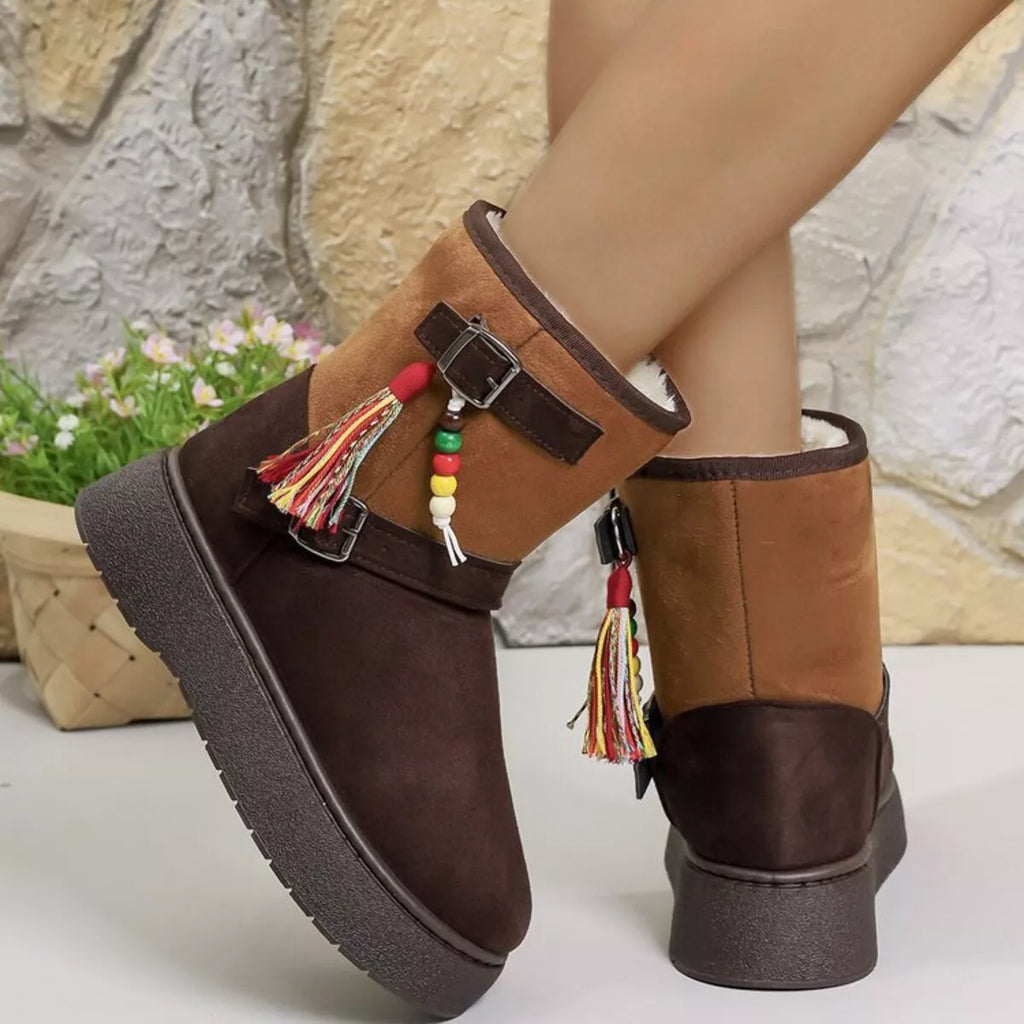 Two-tone ankle boots with brown upper, tan side panels, buckles, and tassels.