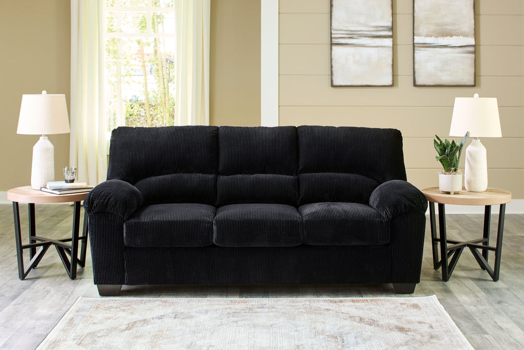 Black velvet-look sofa with tufted back, rounded arms, and three seat cushions