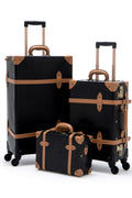 Black hard-shell luggage with tan leather straps, buckles, and wheeled stands