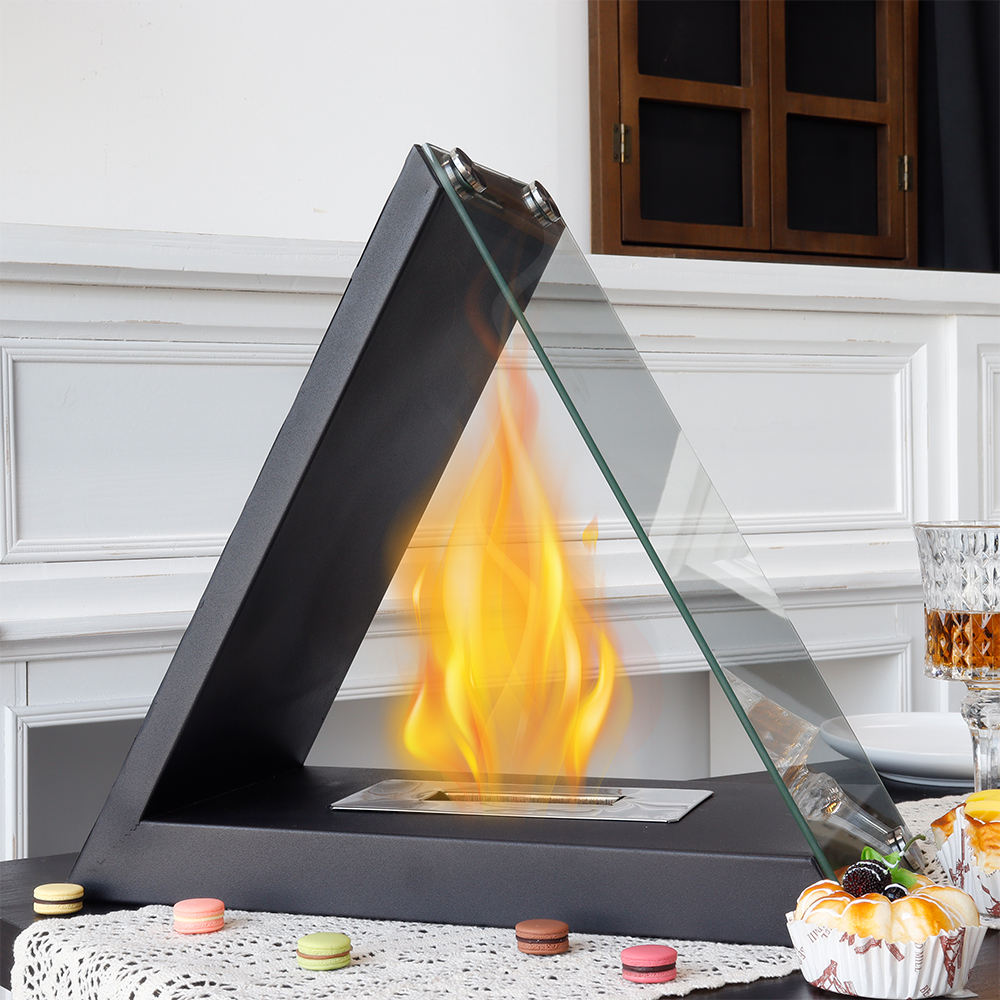 Black triangular tabletop alcohol fireplace with open flame inside and glass shield