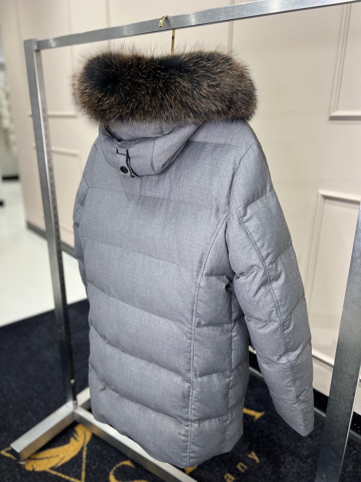 Men's grey puffer coat with dark fur-trim hood and long sleeves