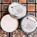 Round dog paw protectant wax balm tin with open jar lid and pale wax inside