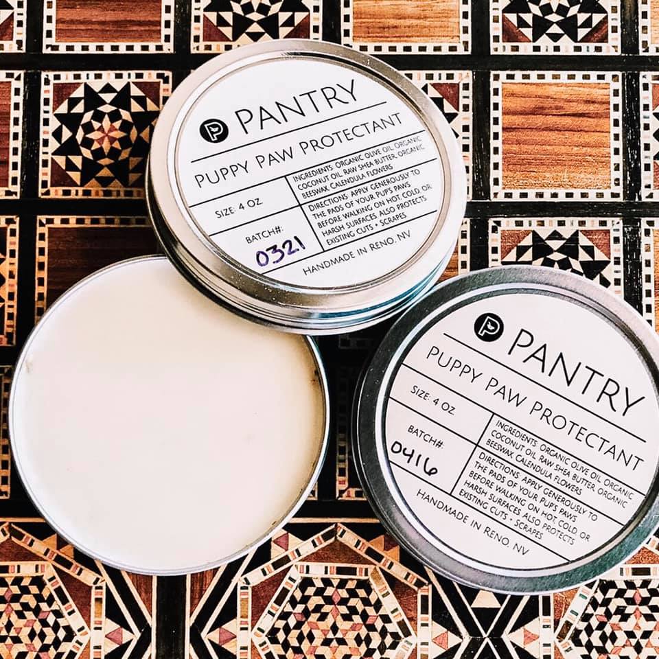 Round dog paw protectant wax balm tin with open jar lid and pale wax inside