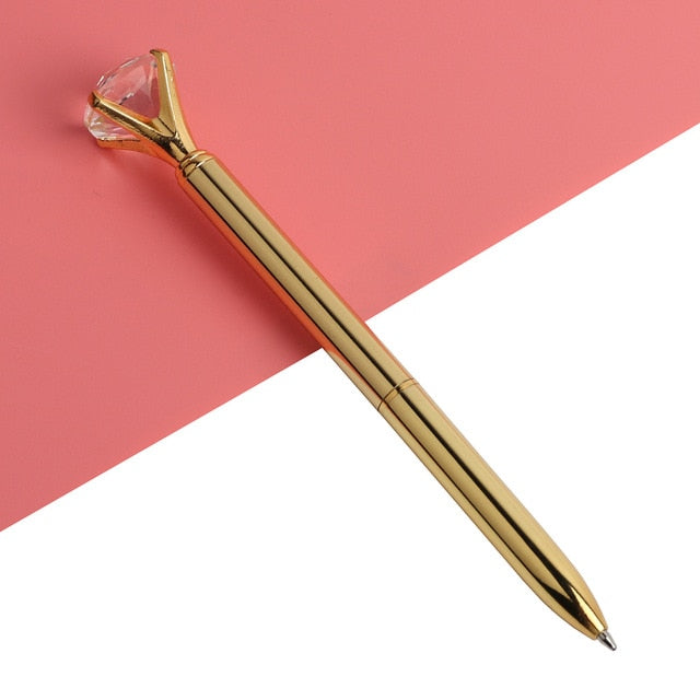 Gold-colored ballpoint pen with faceted gold gem top and metal ballpoint tip