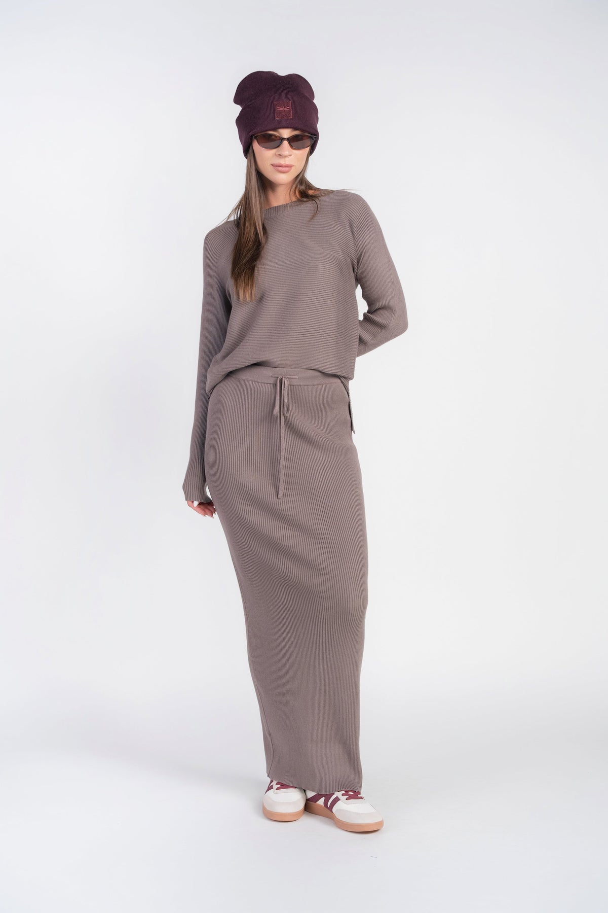 Mushroom ribbed knit sweater top with long sleeves and crew neck, tucked into skirt