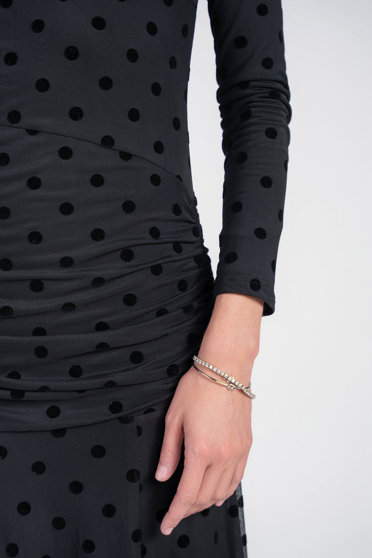 Black mesh dot maxi dress sleeve and hand with ruched fabric, bracelet close-up