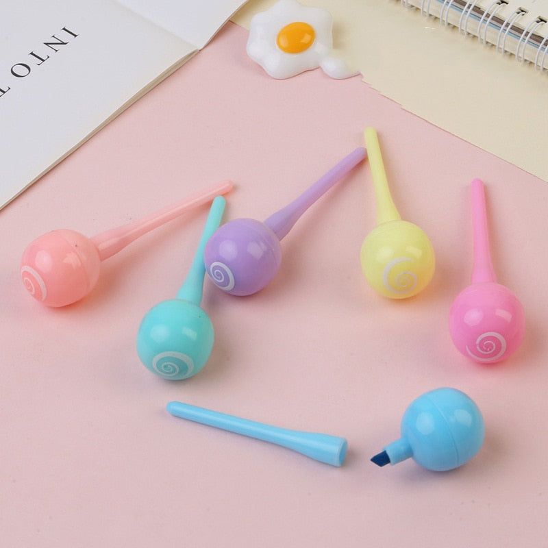 Pastel mini highlighter markers with spiral ends; one orange tip visible.