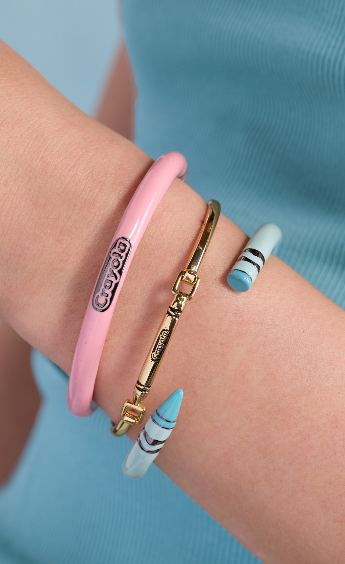 Pink crayon cuff bracelet with Crayola logo and striped ends on wrist
