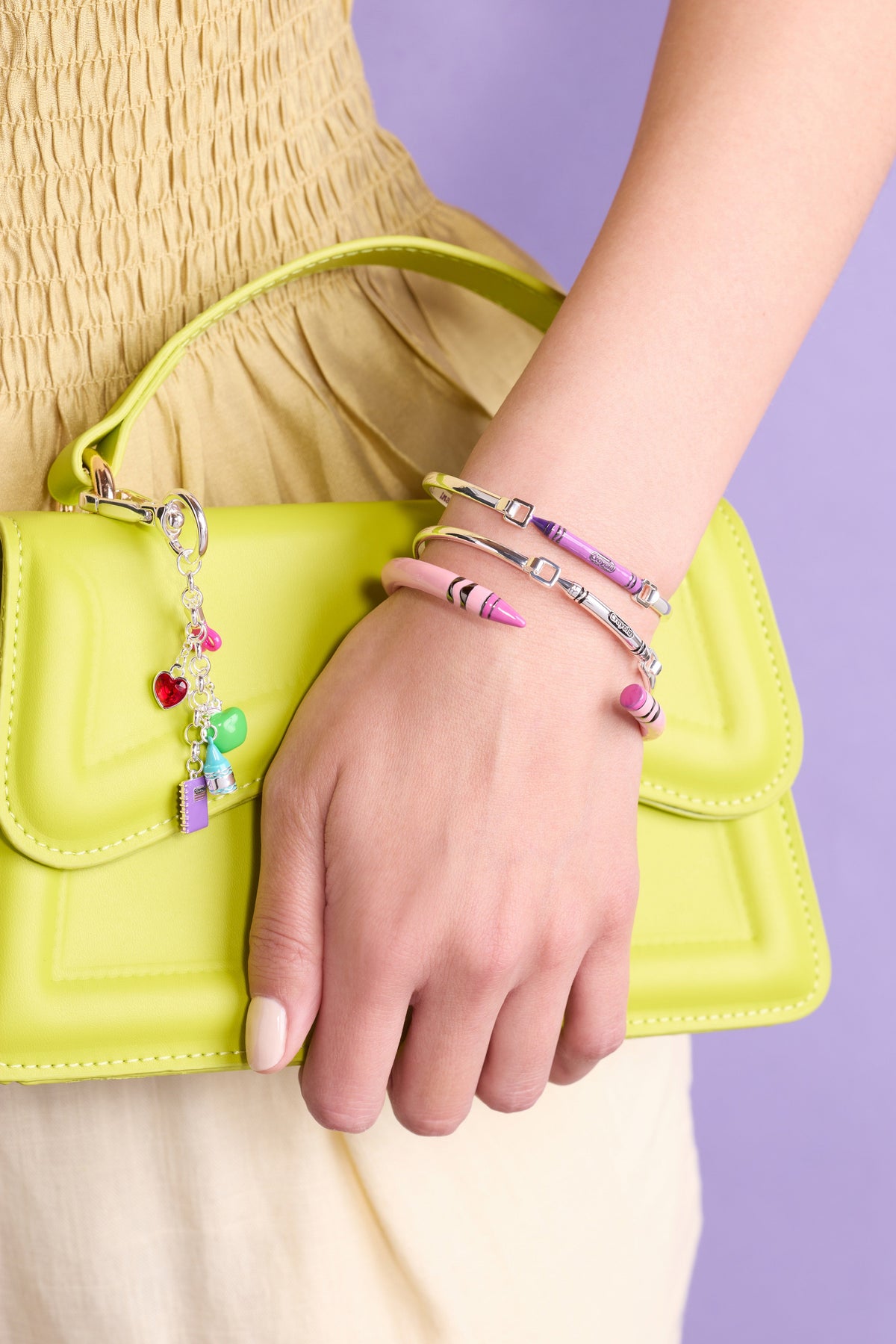 Gold Crayola metal crayon tension bangle on wrist with square clasp