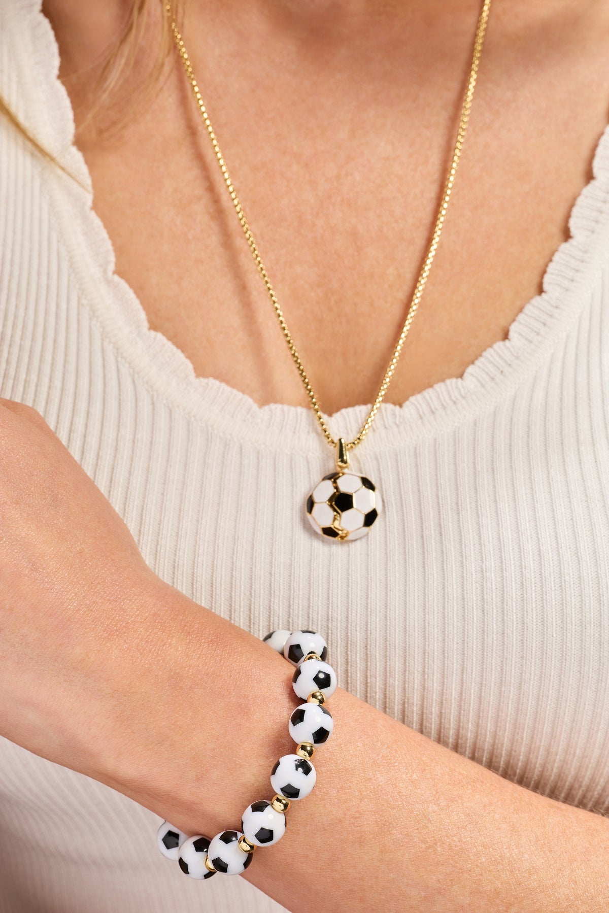 Gold soccer ball locket necklace worn with soccer bead bracelet