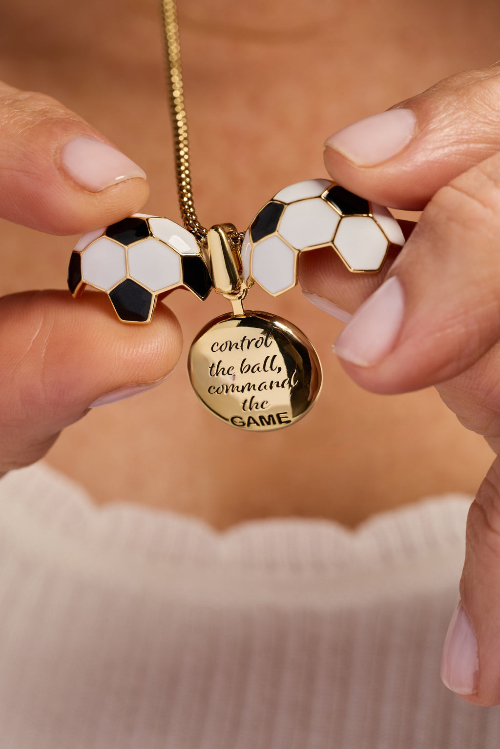 Gold soccer ball locket necklace held in hands with round text locket