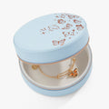 Light blue round jewelry case open with ruffle lining and hanging bangle bracelet
