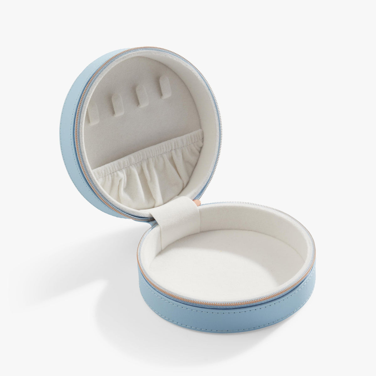 Light blue round jewelry case open showing ring slots and white ruffle lining