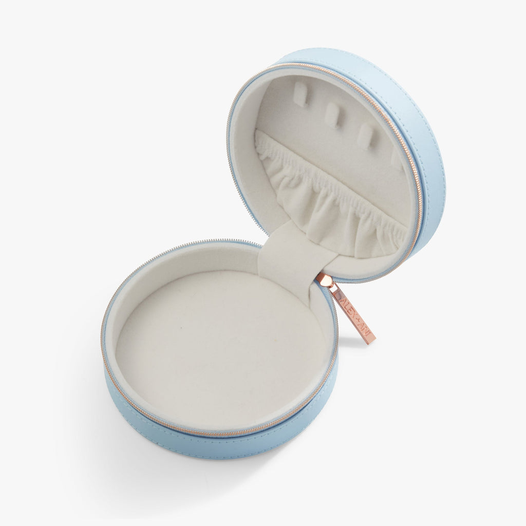 Light blue round jewelry case open with upright necklace slots and white ruffle lining