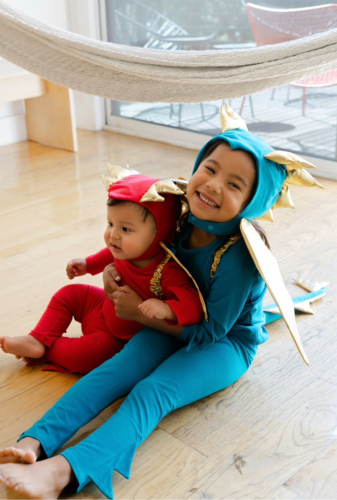 Blue dragon costume jumpsuit with gold-trim hood spikes, worn by child