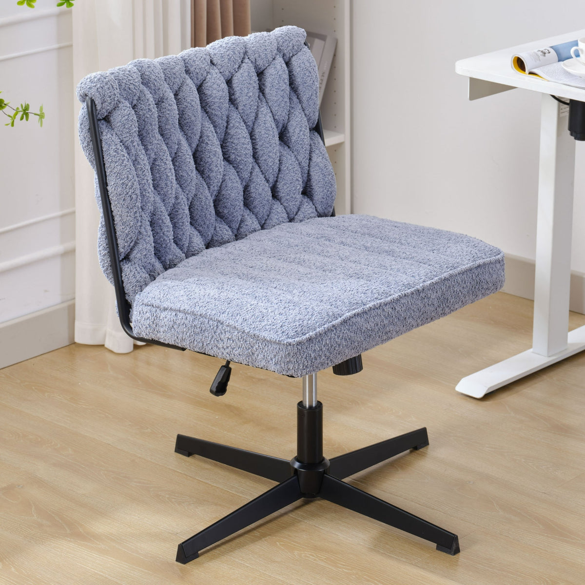 Blue armless office desk chair with tufted back, cushioned seat, black cross base