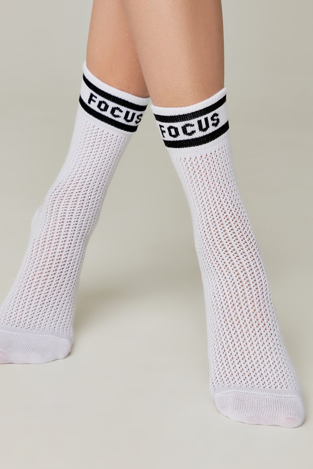 White long cotton socks on legs with mesh knit and 'FOCUS' cuff band