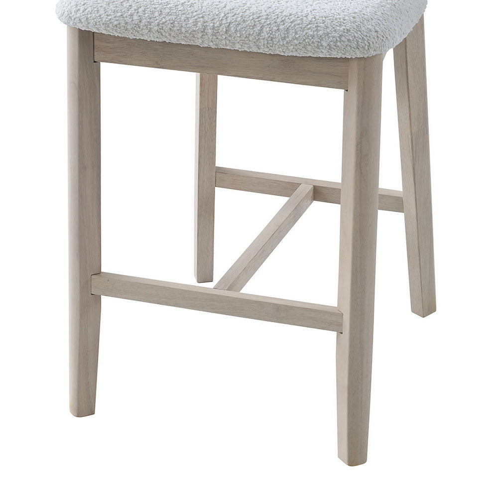 Close view of cream boucle seat on light wood bar stool with cross footrest