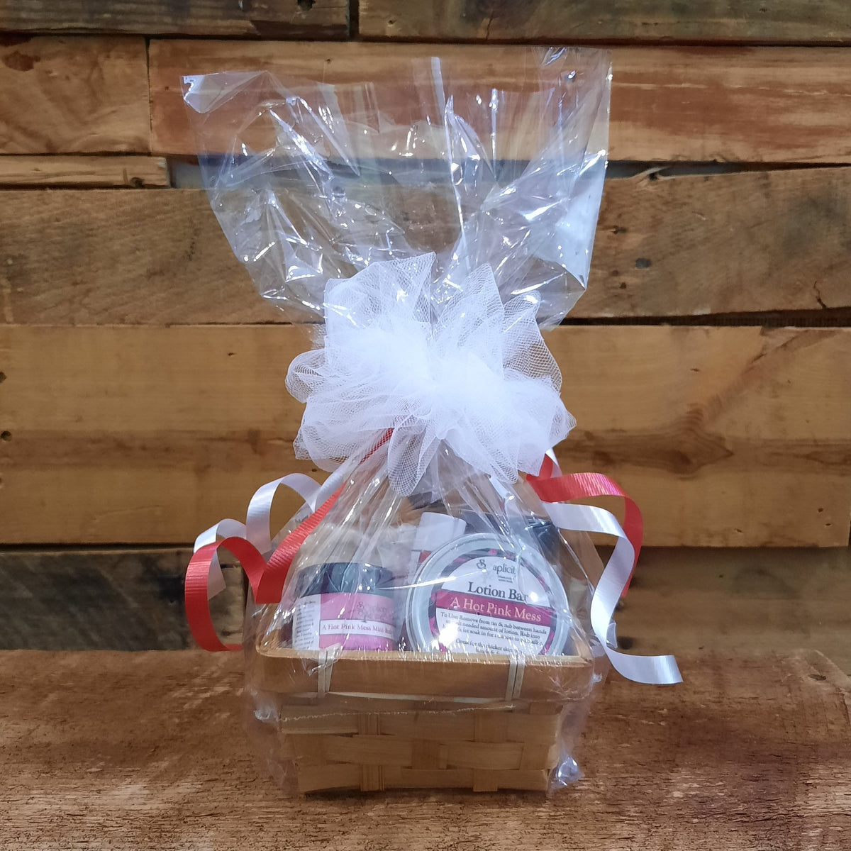 Small scented gift set basket wrapped in clear plastic with white tulle and ribbon