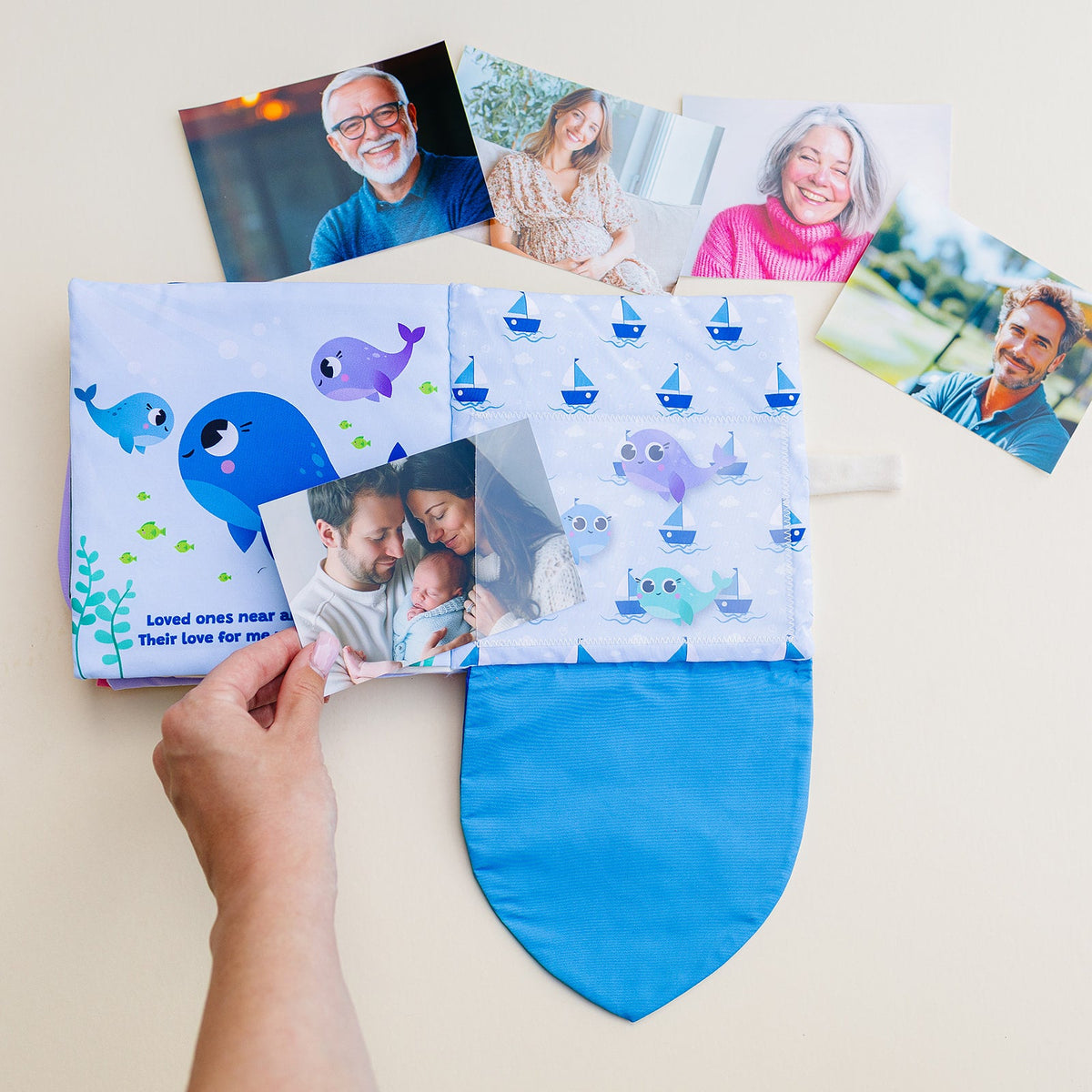 Blue photo-pocket storybook album held open, showing whale illustrations and photo pocket