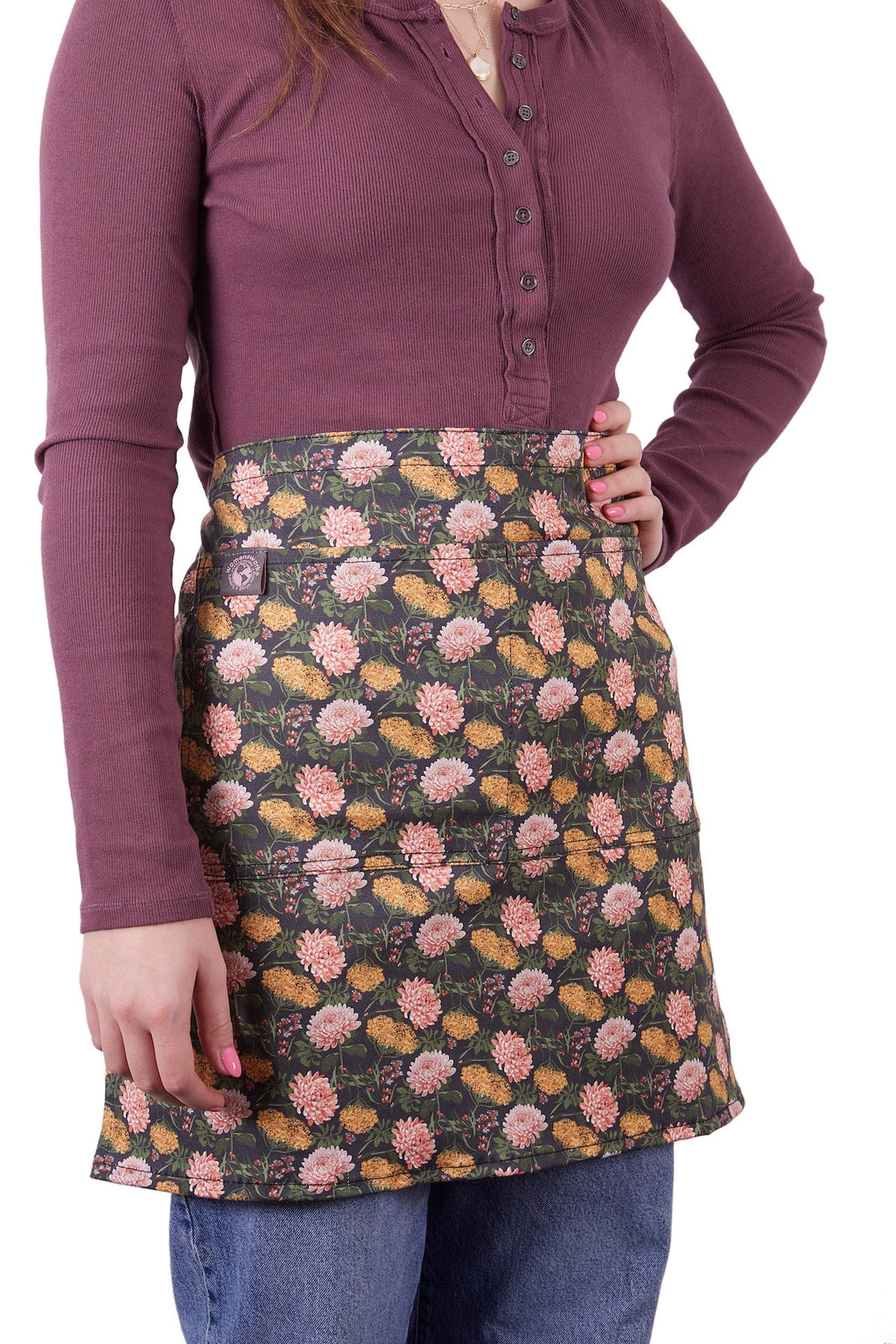 Floral half apron with waist ties and front pocket, dark base with pink flowers