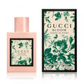 Pink perfume bottle and dark box with Gucci Bloom green floral artwork