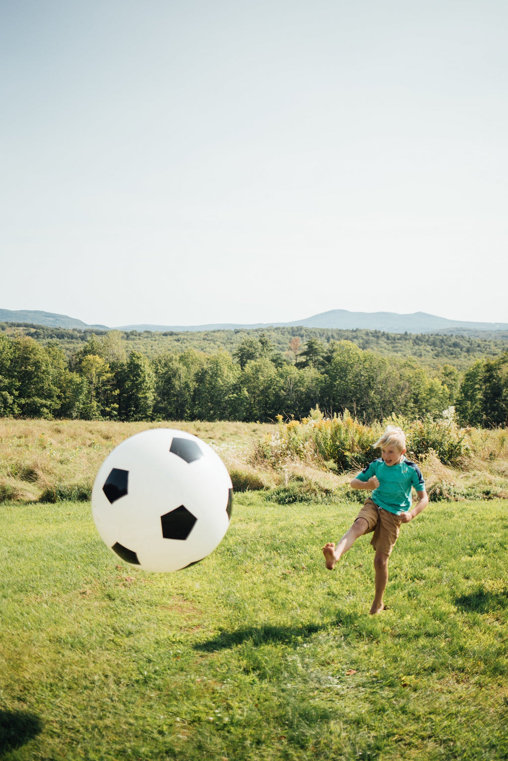 White soccer ball with black pentagon pattern on a grassy field