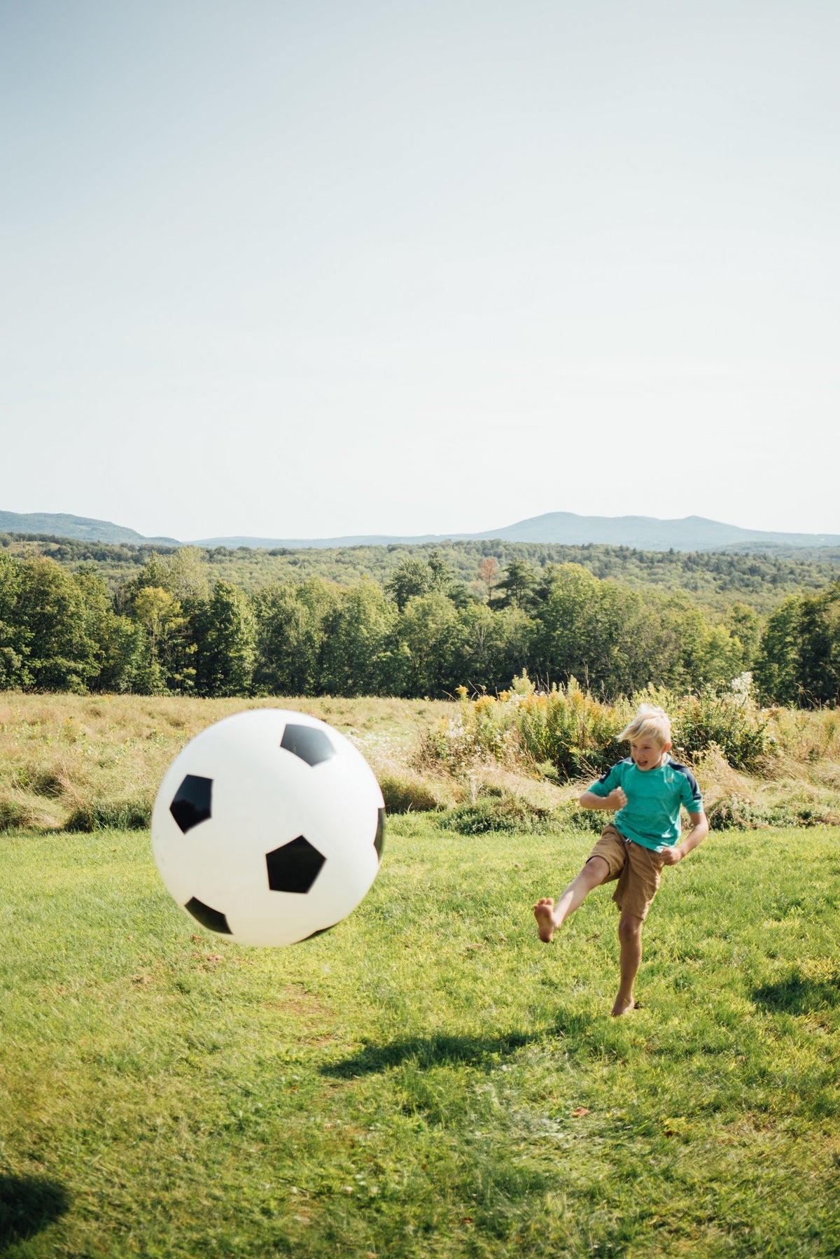 White soccer ball with black pentagon pattern on a grassy field