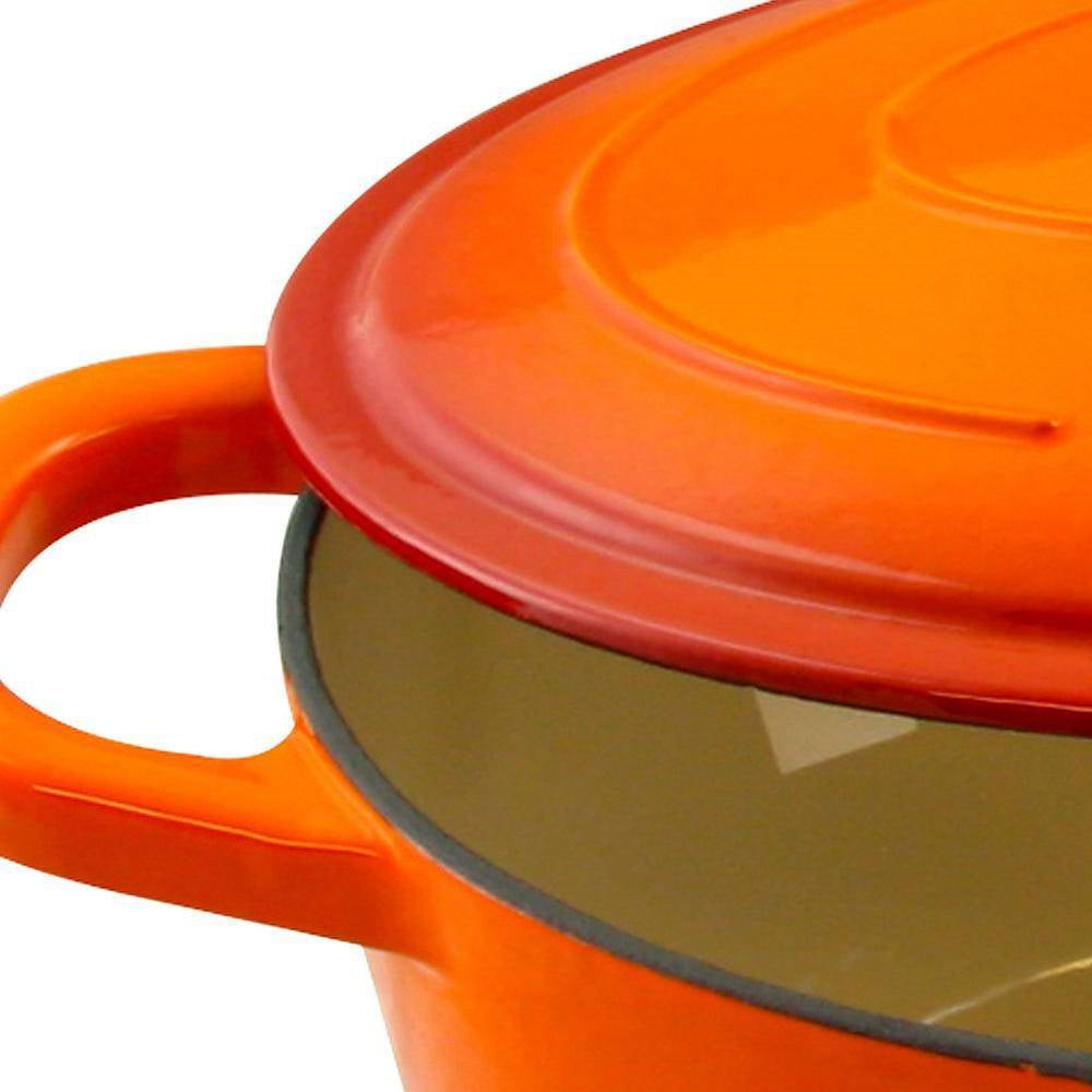 Close-up of orange enameled Dutch oven lid with vent knob and gray interior rim.