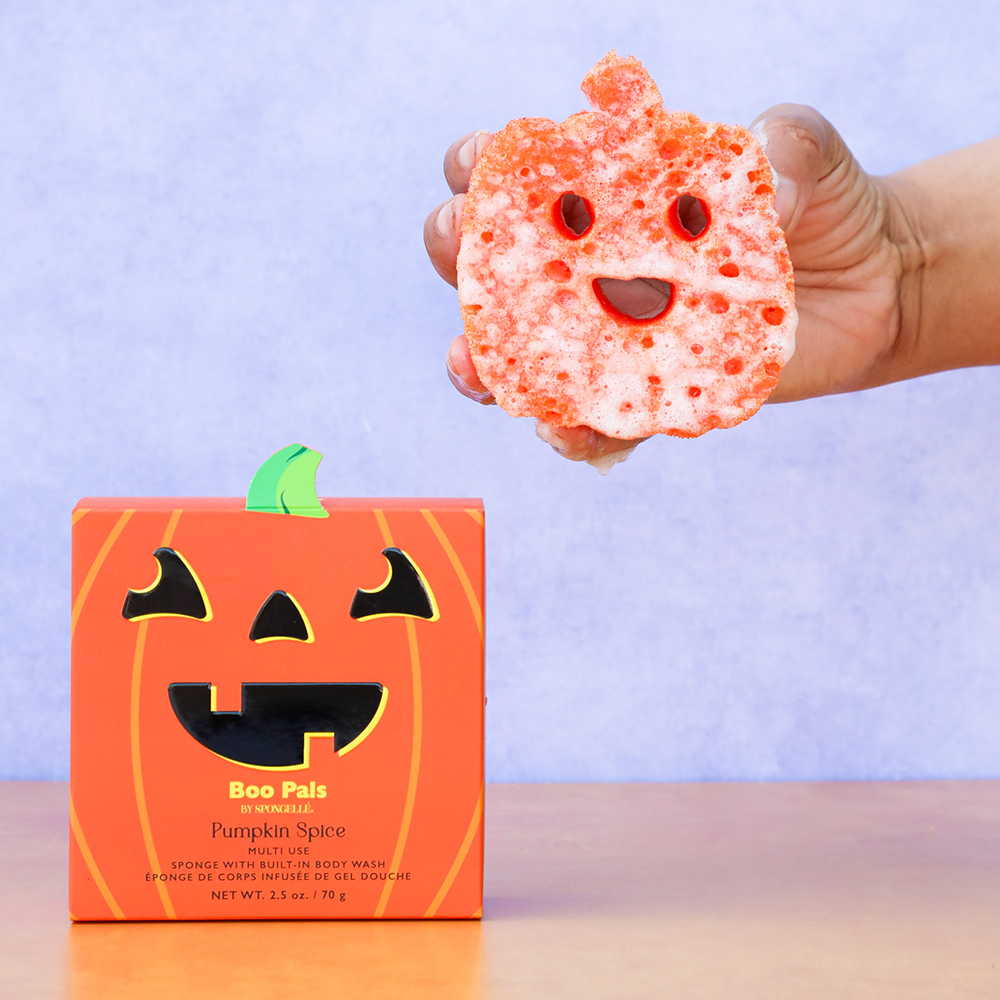 Orange textured jack-o-lantern face sponge buffer held in hand