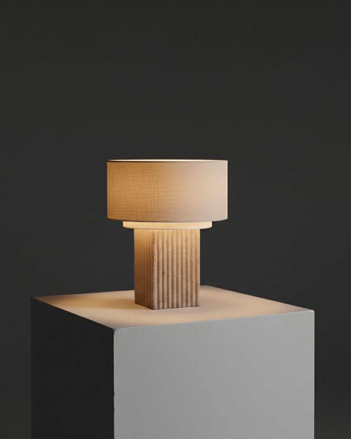 Table lamp with amber-tinted shade and ribbed tan base on white block