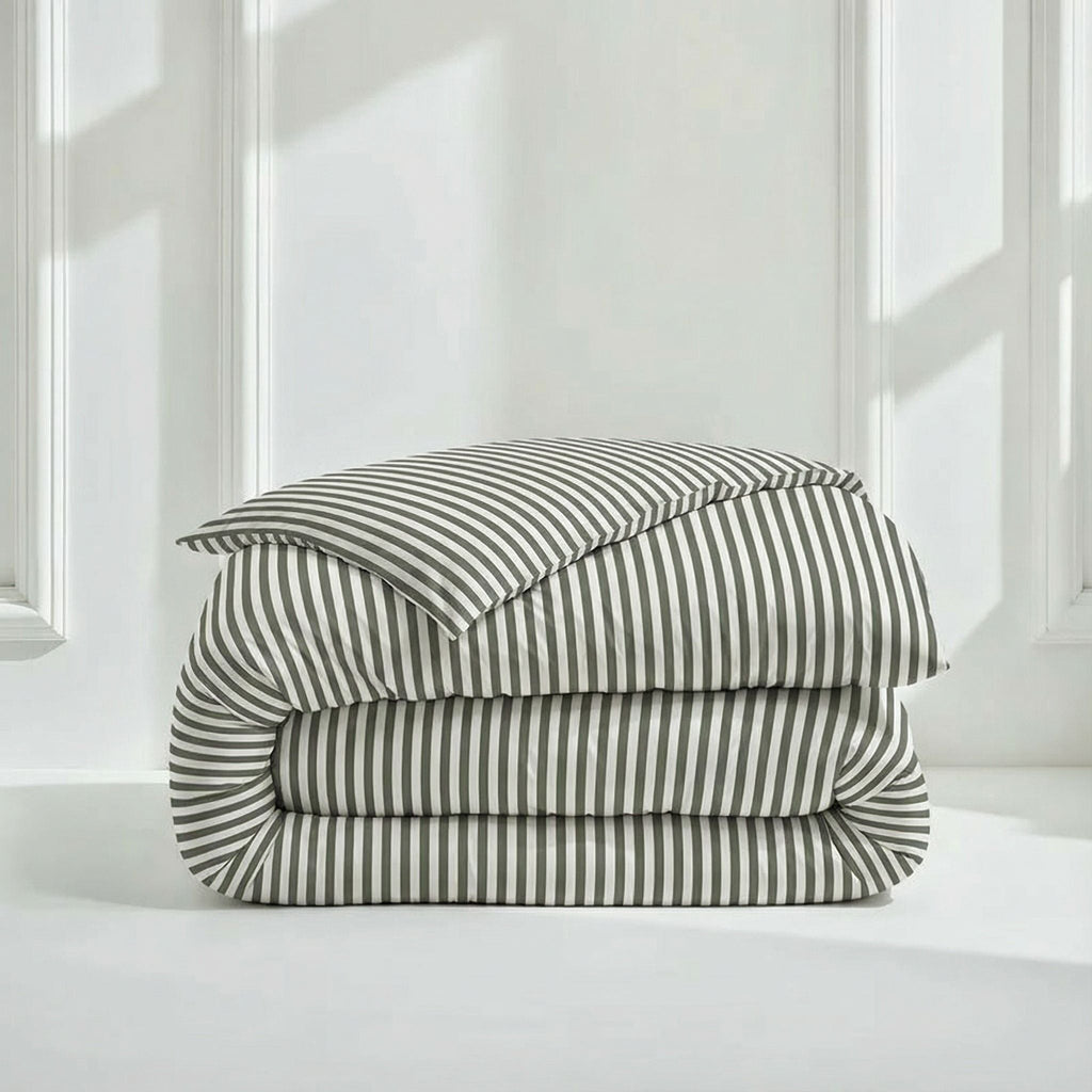 Folded striped sateen comforter with matching pillow shams, white and dark gray.