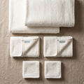 White organic cotton bath towel set, six neatly folded towels with plush texture