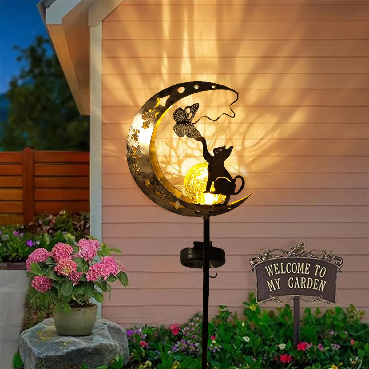 Solar moon-shaped garden lamp with cat and butterfly metal cutout, warm glowing light.