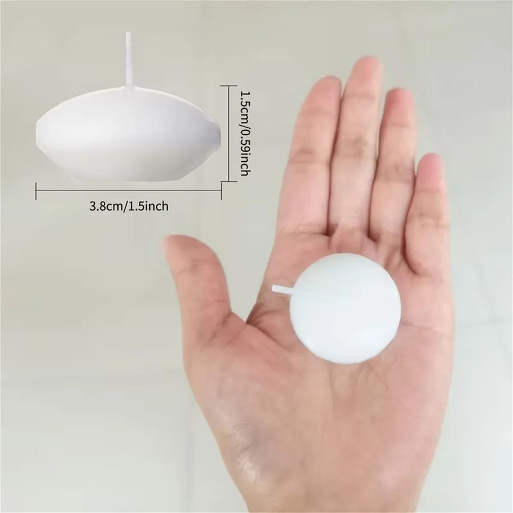 White floating candle disc with wick; shown in palm for size