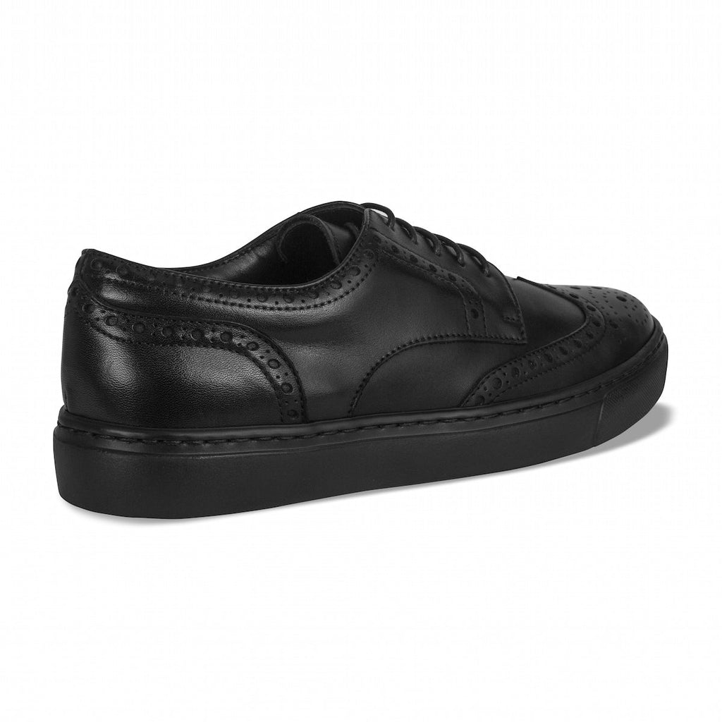 Black lace-up oxford shoe in side view with wingtip perforations and low profile sole