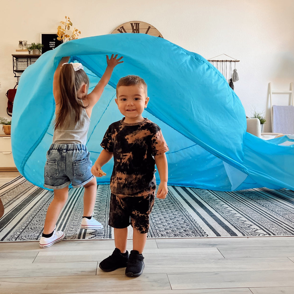 Blue inflatable air fort dome with open entrance, kids holding the fabric