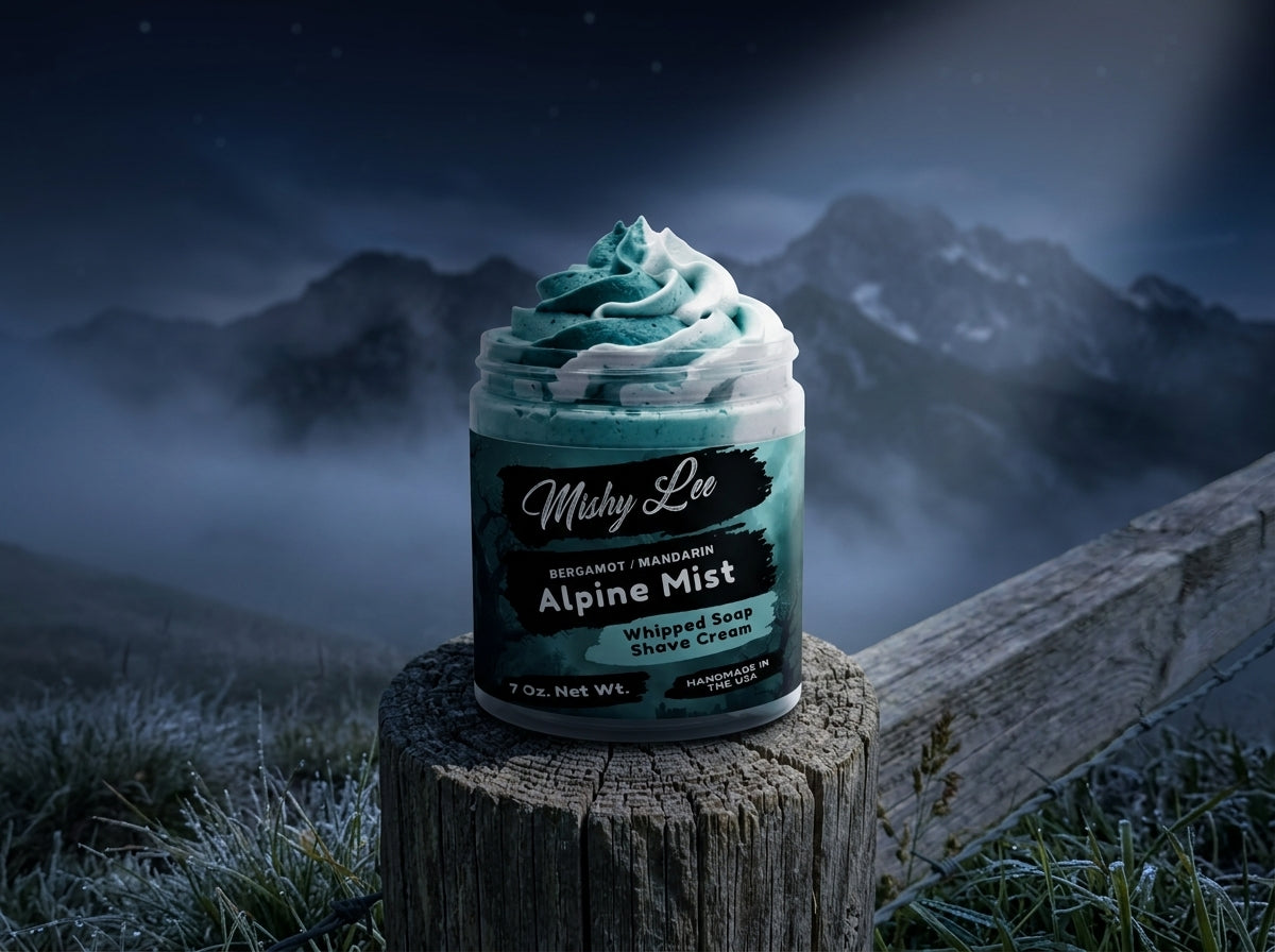 Men’s whipped soap and shave cream jar on tree stump outdoors with misty mountain backdrop.