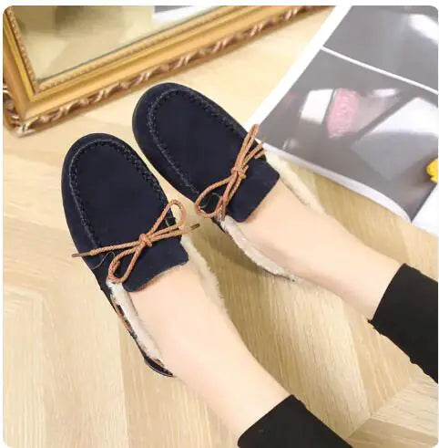 Women's navy plush slip-on moccasin flats with tan lace tie detail and fleece trim