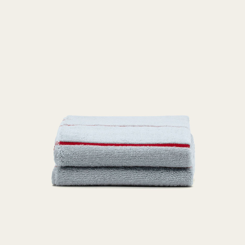 Gray cotton hand towel with two red stripe bands, folded