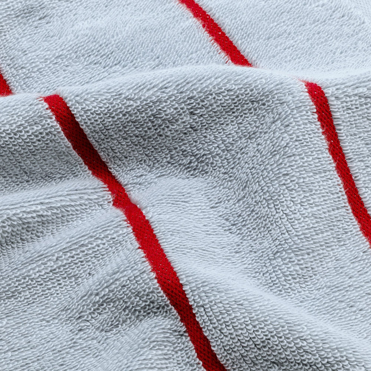 Cotton towel fabric close-up in light blue with red stripe accents