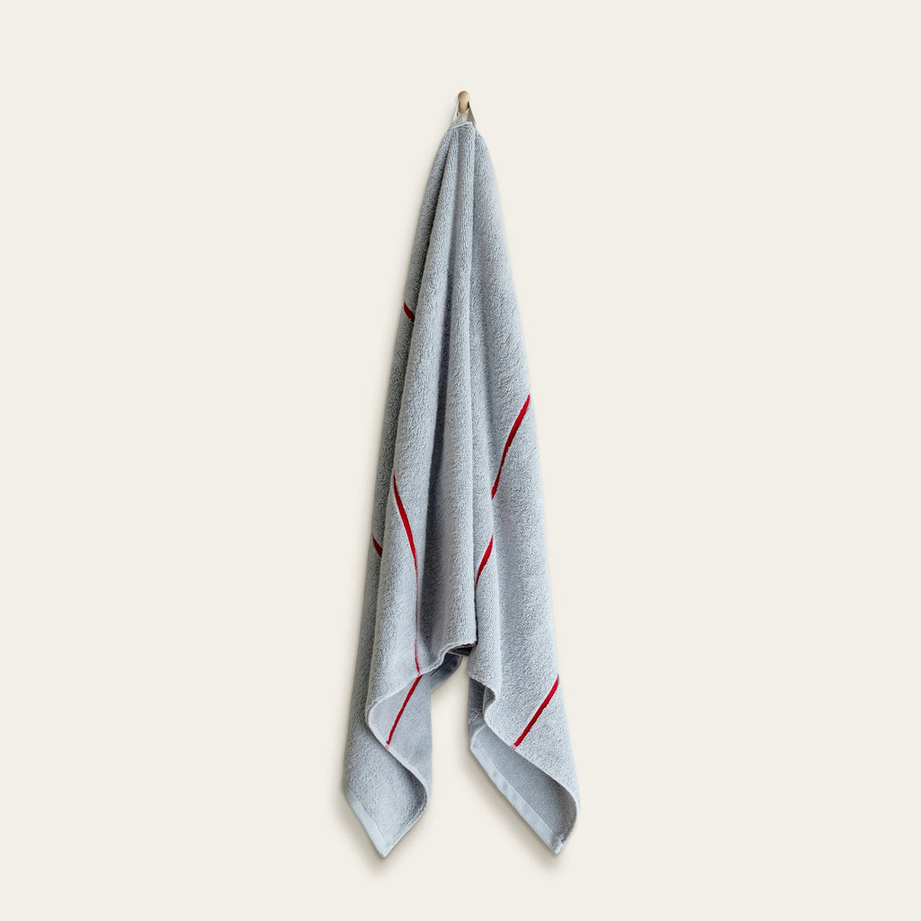 Light blue cotton towel with red vertical stripe accents, folded with stitched edges