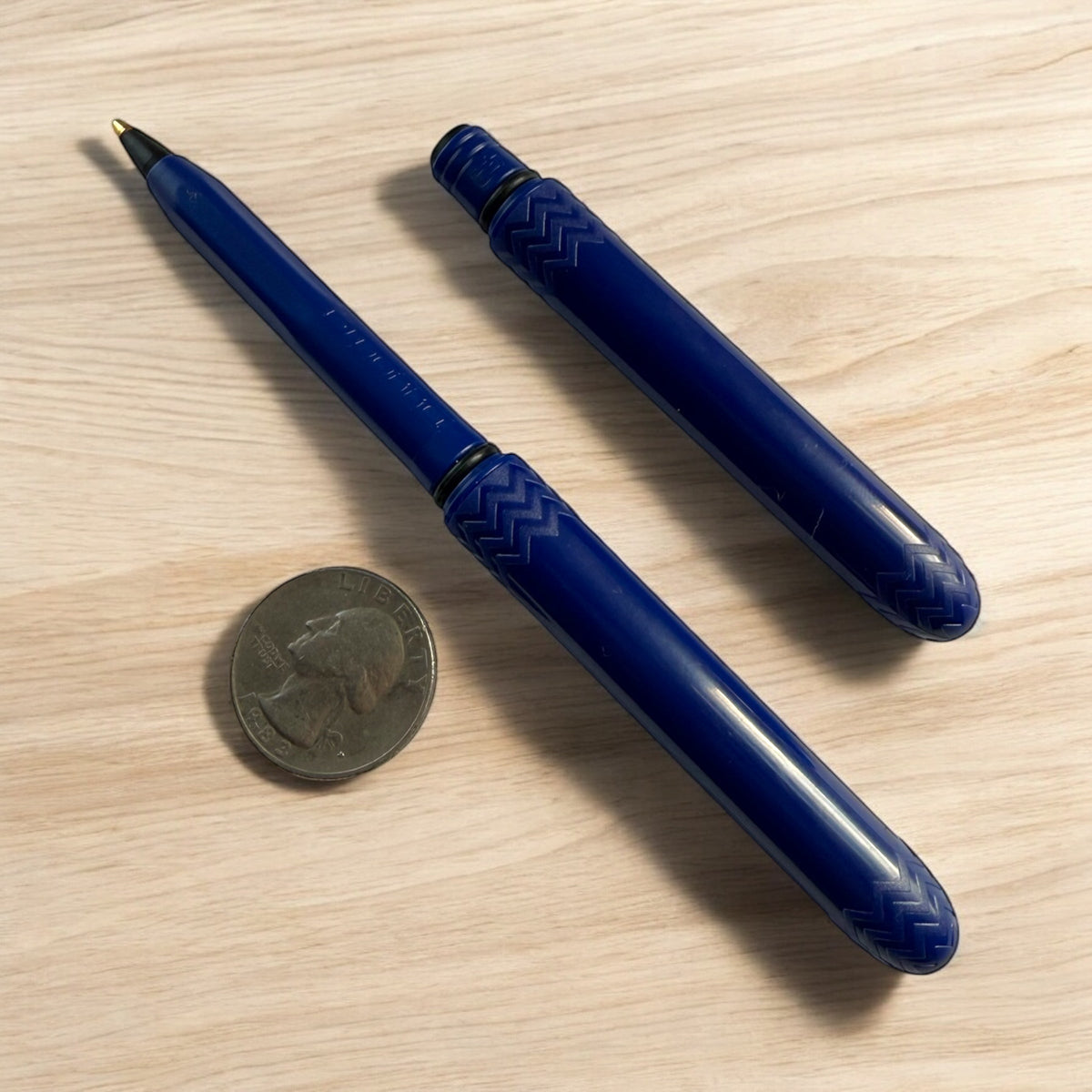 Indigo pocket pens: two blue pens with textured grip, gold tips, on wood
